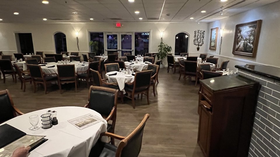 Warm dining room with table settings and framed wall art.