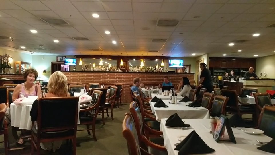 Italian restaurant interior with booths and soft overhead lighting.